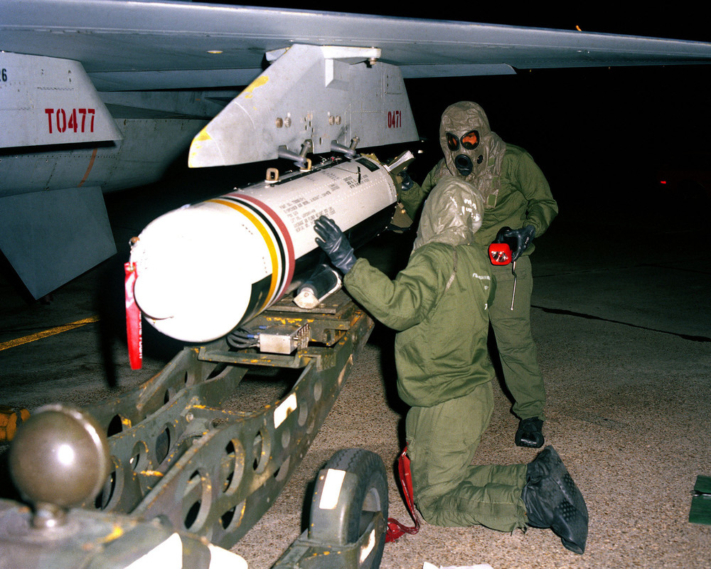 a-munitions-crew-attaches-a-cbu-87b-cluster-bomb-to-the-wing-pylon-of-an-f-11fa39-1600.jpg